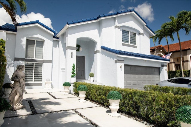 view of front of property featuring a tiled roof, stucco siding, and an attached garage