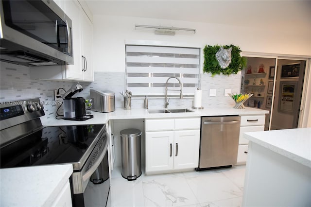 kitchen featuring light countertops, a sink, white cabinetry, appliances with stainless steel finishes, and marble finish floor