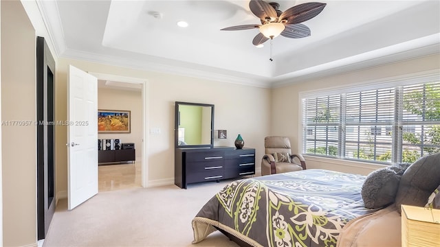 bedroom featuring a tray ceiling, ornamental molding, baseboards, light colored carpet, and ceiling fan