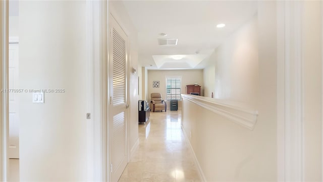 corridor featuring light tile patterned floors, a tray ceiling, baseboards, visible vents, and recessed lighting