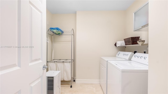 laundry area with baseboards, washer and dryer, and laundry area