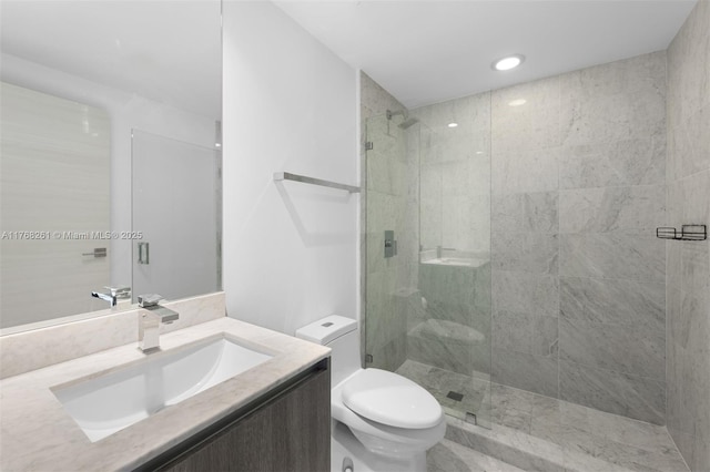 bathroom with toilet, vanity, and a shower stall