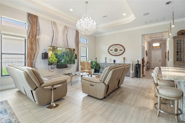 living room featuring visible vents, a chandelier, a raised ceiling, and crown molding