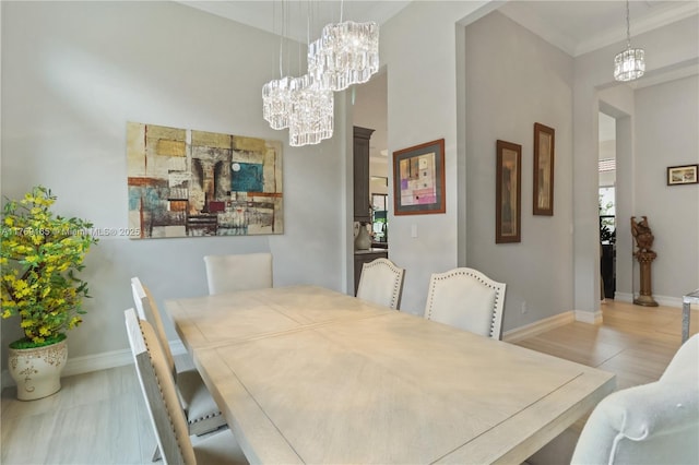 dining area featuring baseboards, a notable chandelier, and ornamental molding