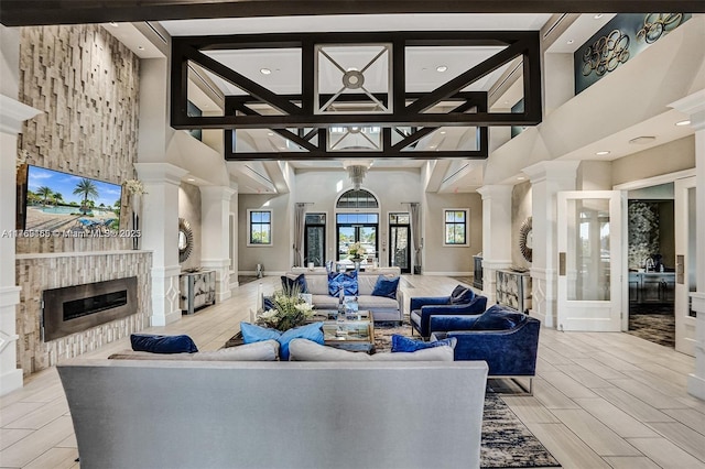 11812 S Cantal Cir S, Parkland, FL 33076 - living area featuring a high ceiling, a glass covered fireplace, recessed lighting, beam ceiling, and ornate columns