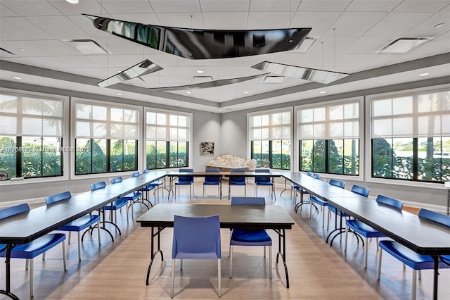 interior space featuring plenty of natural light, visible vents, a drop ceiling, and light wood-type flooring