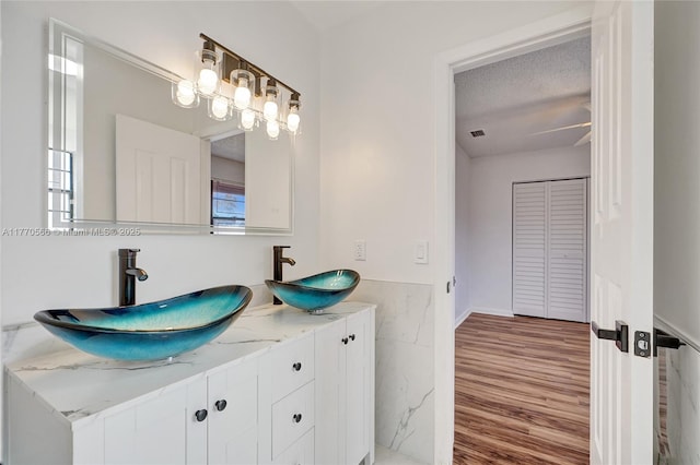 2030 Bayberry Dr Unit 2030, Pembroke Pines, FL 33024 - full bathroom with tile walls, a wainscoted wall, wood finished floors, double vanity, and a textured ceiling
