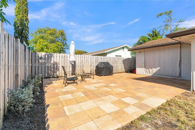 view of patio featuring a fenced backyard and a grill