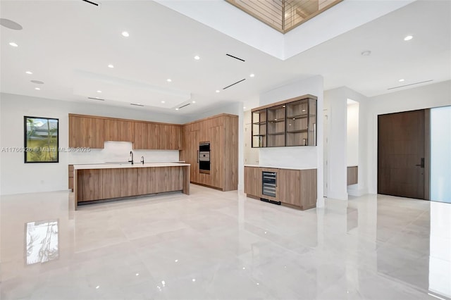 1419 N Lakeside Dr, Lake Worth, FL 33460 - kitchen featuring modern cabinets, beverage cooler, light countertops, a large island, and recessed lighting