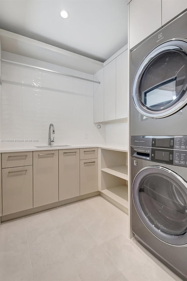 1419 N Lakeside Dr, Lake Worth, FL 33460 - laundry area featuring stacked washer and clothes dryer, cabinet space, and light tile patterned floors