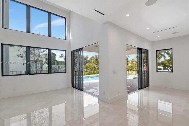 1419 N Lakeside Dr, Lake Worth, FL 33460 - empty room featuring healthy amount of natural light, recessed lighting, baseboards, and a towering ceiling
