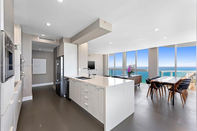 kitchen featuring modern cabinets, stainless steel appliances, a sink, and light countertops
