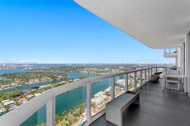 balcony with a water view and a view of city
