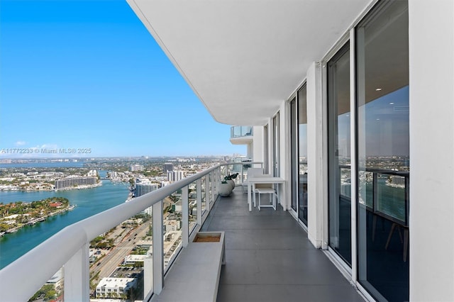 balcony with a water view and a view of city
