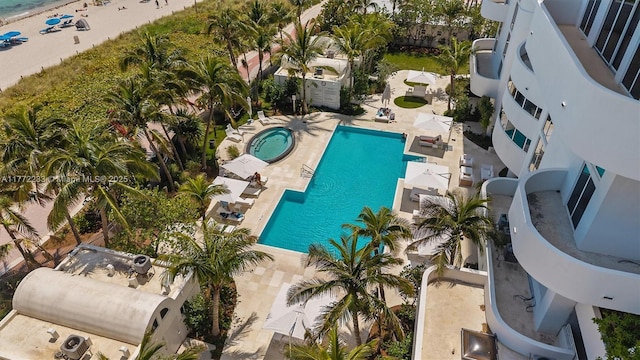 pool with a hot tub and a patio