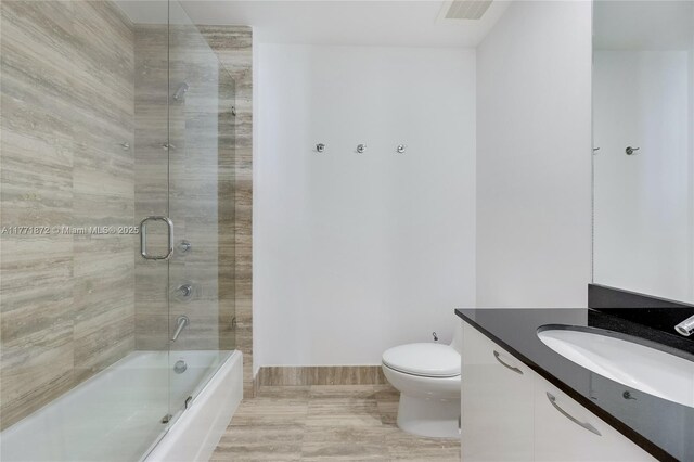 15811 Collins Ave Unit 2101, Sunny Isles Beach, FL 33160 - full bathroom featuring vanity, toilet, shower / bath combination with glass door, and baseboards