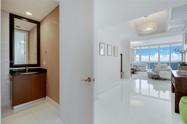 15811 Collins Ave Unit 2101, Sunny Isles Beach, FL 33160 - corridor featuring a sink, baseboards, and light tile patterned floors