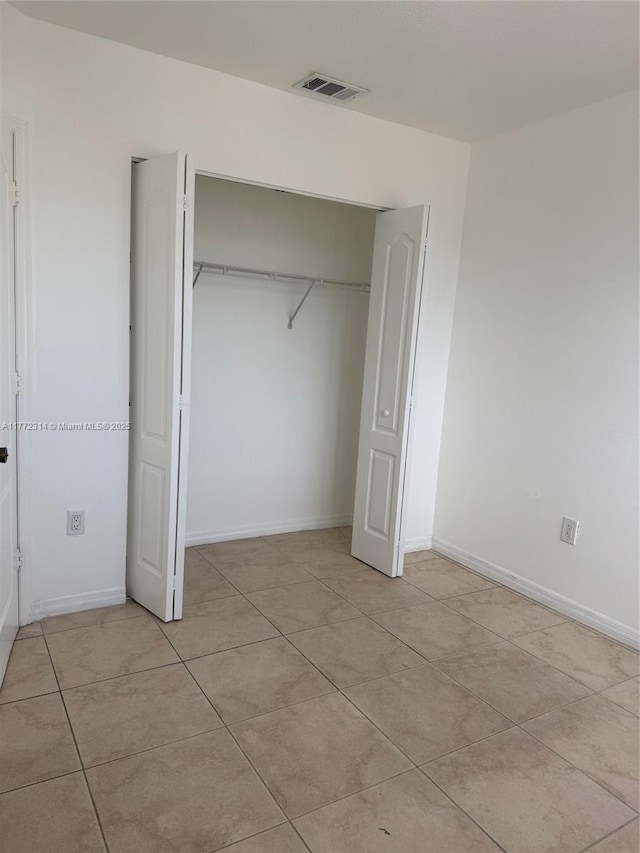 130 SW 109th Ave Unit 7, Sweetwater, FL 33174 - unfurnished bedroom featuring light tile patterned flooring, a closet, and baseboards