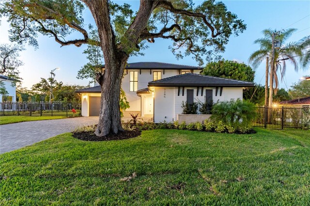 7285 SW 72nd Ter, Miami, FL 33143 - view of front facade featuring decorative driveway, stucco siding, and a garage