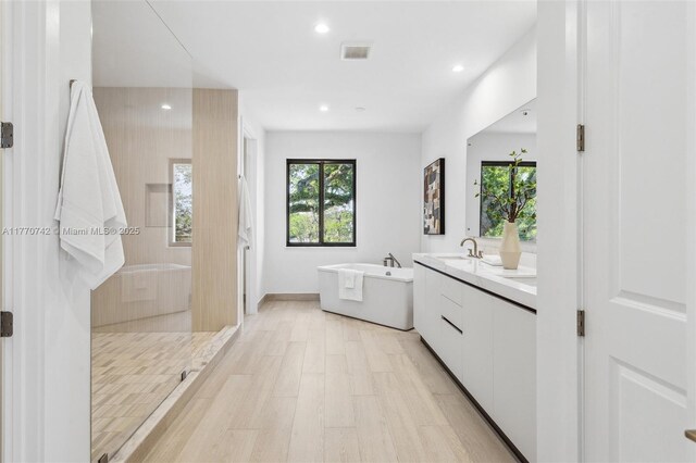 7285 SW 72nd Ter, Miami, FL 33143 - full bathroom featuring a freestanding bath, double vanity, recessed lighting, walk in shower, and wood finished floors