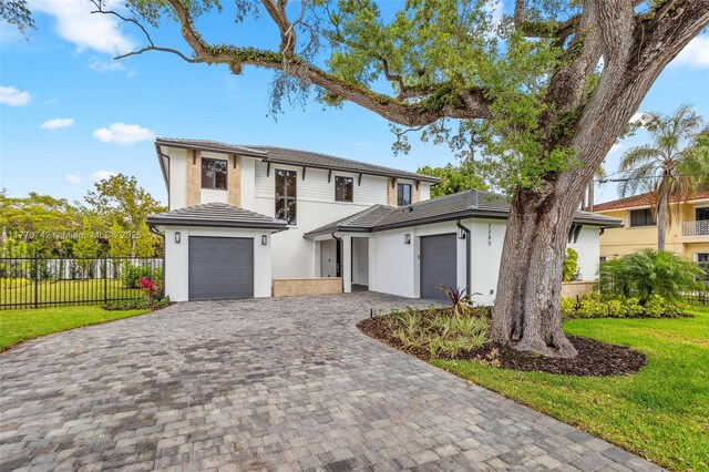 7285 SW 72nd Ter, Miami, FL 33143 - view of front of property with decorative driveway, an attached garage, stucco siding, and a tiled roof