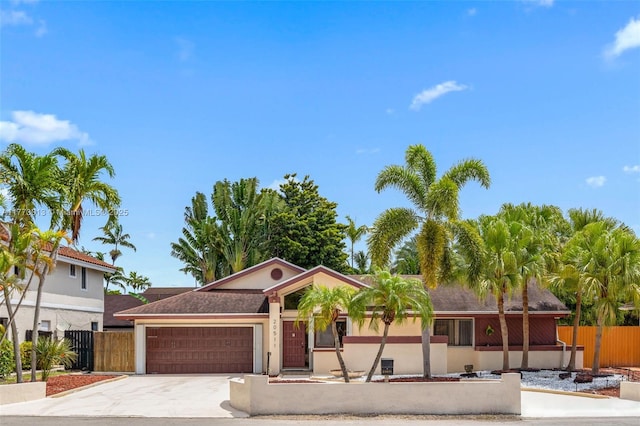 ranch-style home with stucco siding, a garage, fence, and driveway