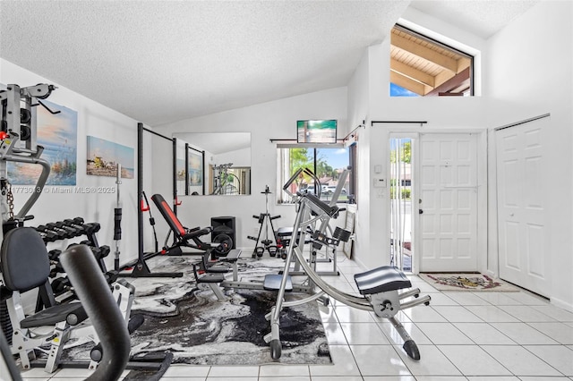 interior space featuring a textured ceiling, light tile patterned floors, and lofted ceiling