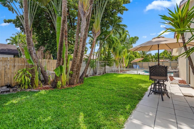 view of yard featuring a patio, a fenced in pool, and a fenced backyard