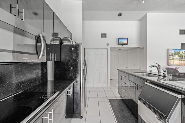 kitchen with visible vents, gray cabinets, a sink, appliances with stainless steel finishes, and light tile patterned floors