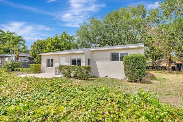 2331 NW 92nd St, Miami, FL 33147 - rear view of house featuring a patio, fence, a lawn, and stucco siding