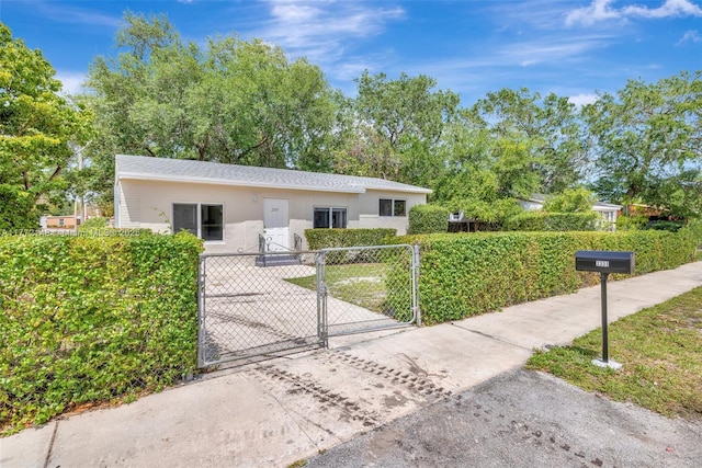 2331 NW 92nd St, Miami, FL 33147 - ranch-style home featuring stucco siding, a gate, fence, and concrete driveway