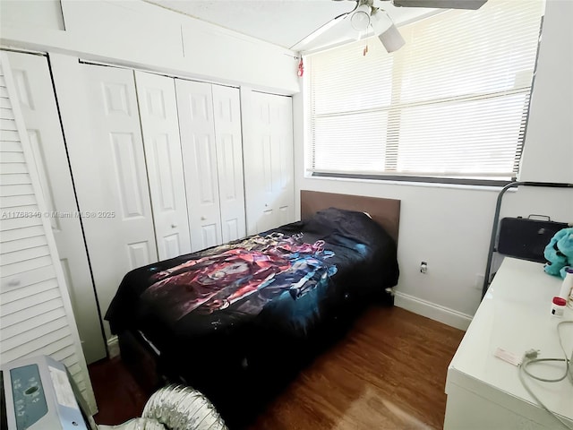 bedroom featuring baseboards, ceiling fan, wood finished floors, and multiple windows