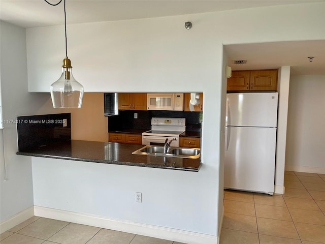2400 SW 3rd Ave Unit 605, Miami, FL 33129 - kitchen featuring a sink, a peninsula, light tile patterned floors, white appliances, and dark countertops