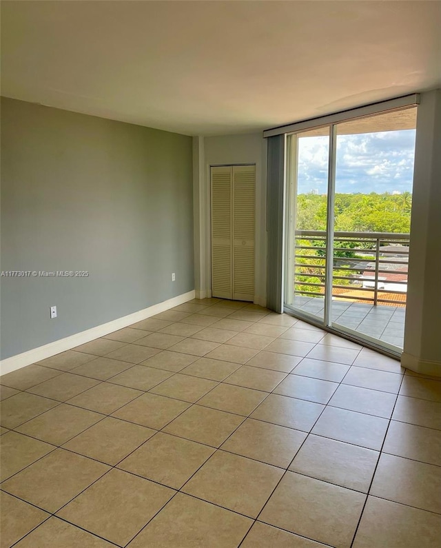 2400 SW 3rd Ave Unit 605, Miami, FL 33129 - empty room featuring a wall of windows, baseboards, and light tile patterned floors