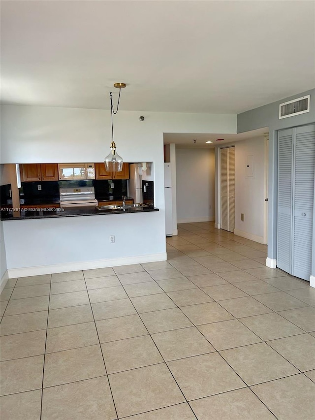 2400 SW 3rd Ave Unit 605, Miami, FL 33129 - kitchen with light tile patterned floors, hanging light fixtures, dark countertops, electric range oven, and visible vents
