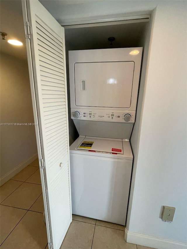 2400 SW 3rd Ave Unit 605, Miami, FL 33129 - washroom with baseboards, stacked washing maching and dryer, laundry area, and light tile patterned floors