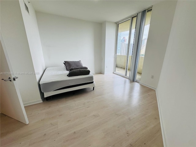 19501 W Country Club Dr Unit 1006, Aventura, FL 33180 - bedroom featuring expansive windows, light wood-style flooring, baseboards, and access to outside