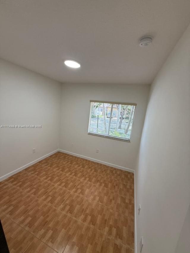 unfurnished room featuring baseboards and light wood-type flooring