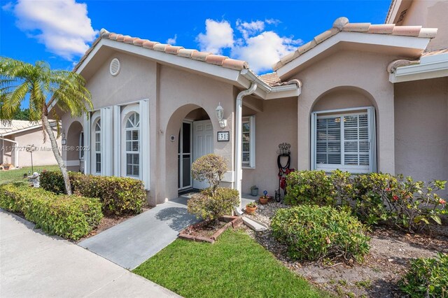 3171 Holiday Springs Blvd Unit 31-5, Margate, FL 33063 - doorway to property with stucco siding and a tiled roof