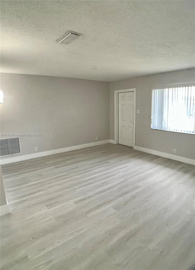 6990 NW 17th St, Margate, FL 33063 - unfurnished room with a textured ceiling, visible vents, and wood finished floors