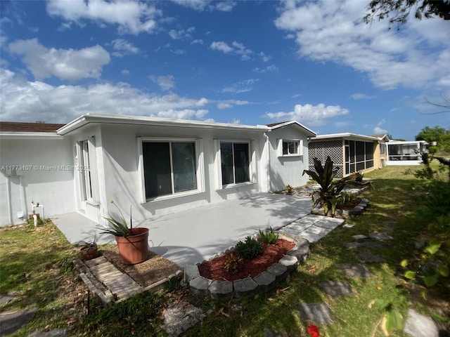 6990 NW 17th St, Margate, FL 33063 - rear view of house with stucco siding, a sunroom, and a patio area