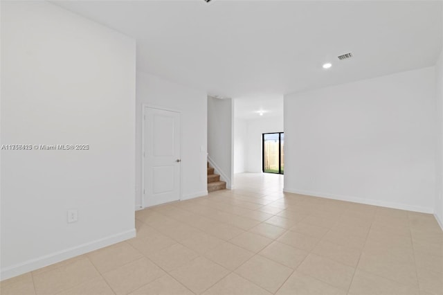 empty room featuring stairway, recessed lighting, baseboards, light tile patterned flooring, and visible vents