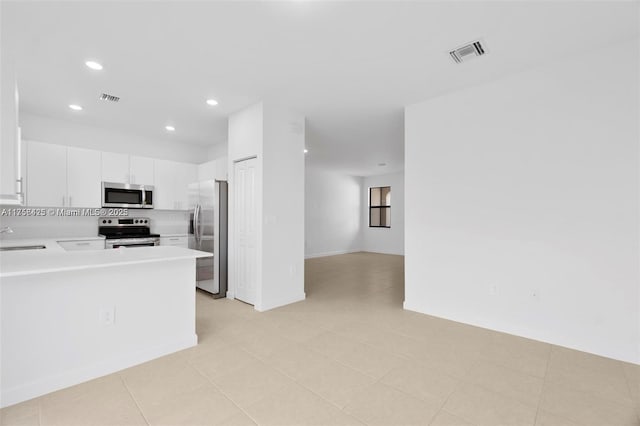 kitchen with white cabinets, light countertops, appliances with stainless steel finishes, and visible vents