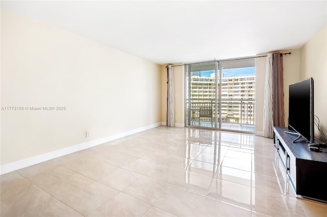 1849 S Ocean Dr Unit 711, Hallandale Beach, FL 33009 - unfurnished living room with floor to ceiling windows, light tile patterned floors, and baseboards