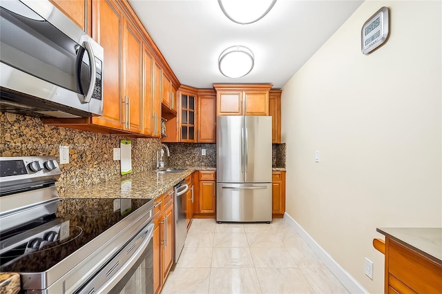1849 S Ocean Dr Unit 711, Hallandale Beach, FL 33009 - kitchen featuring appliances with stainless steel finishes, brown cabinets, a sink, decorative backsplash, and stone counters