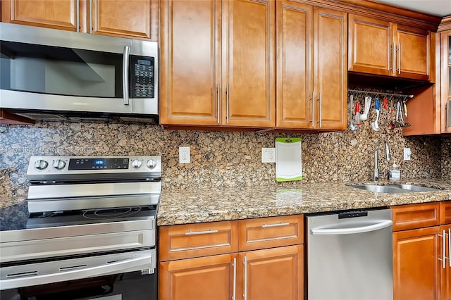 1849 S Ocean Dr Unit 711, Hallandale Beach, FL 33009 - kitchen featuring appliances with stainless steel finishes, a sink, decorative backsplash, light stone countertops, and brown cabinetry
