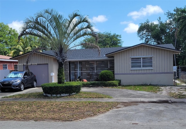 ranch-style house with roof with shingles, driveway, fence, and an attached garage