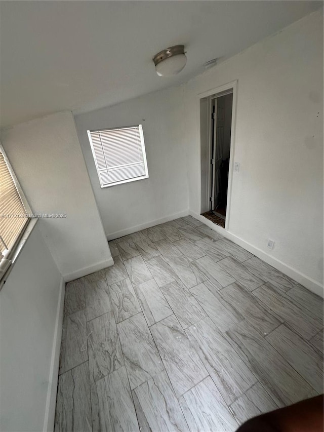 unfurnished room featuring baseboards