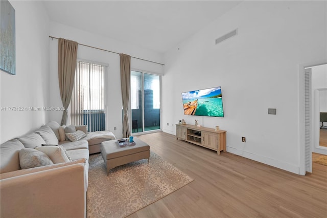 244 Biscayne Blvd Unit 206, Miami, FL 33132 - living area with light wood-style floors, baseboards, and a towering ceiling