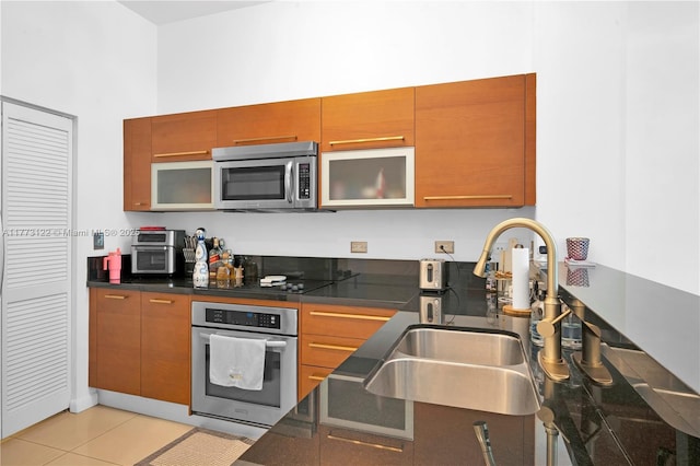 244 Biscayne Blvd Unit 206, Miami, FL 33132 - kitchen featuring appliances with stainless steel finishes, a sink, brown cabinets, and light tile patterned floors